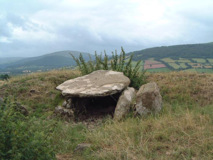 Ty Illtyd SO 0984 2637
A Black Mountains group long cairn measuring 75’ by 51’ with a rectangular N-facing burial chamber set off-centre. It has 3 wallstones and a sloping capstone and was over 4' high but the floor level has risen over the years so that the clearance is now under 3'. The chamber opens on to a rectangular forecourt.