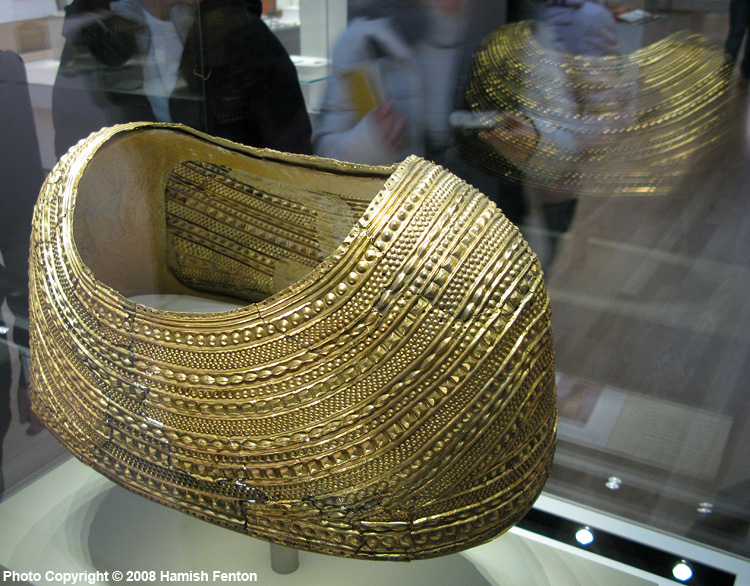 The Mold Cape (Bronze Age), in the British Museum.

The Mold Gold Cape found by workmen quarrying for stone in a burial mound in Mold, Flintshire, North Wales in 1833. In the centre of the mound there was a stone lined cist containing an inhumation burial and the cape was found on the shoulders of the skeleton, pieces of sheet bronze were also recovered which may have formed a backing to the gol