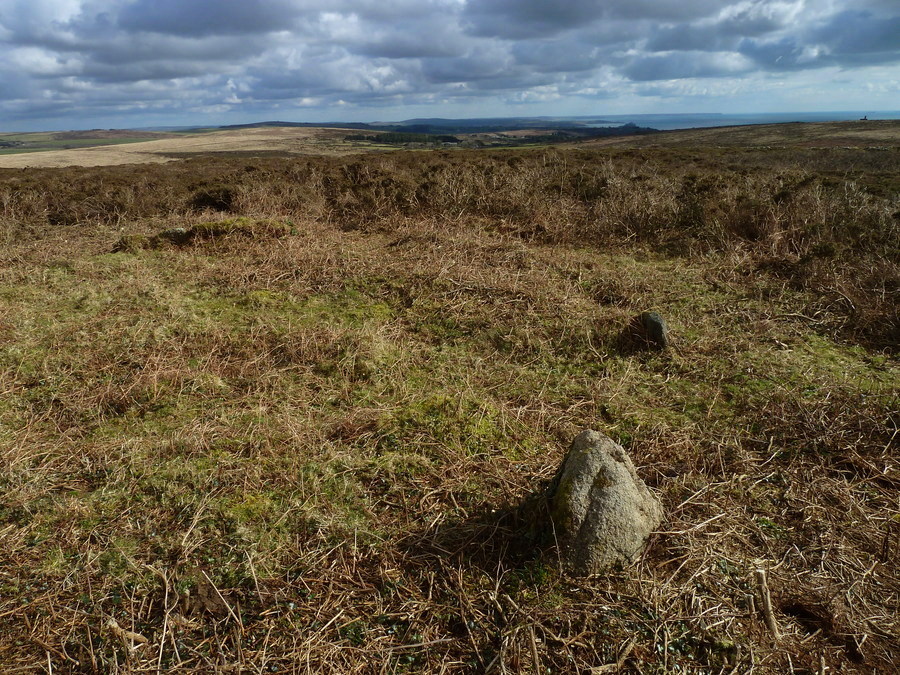 South East Kerbstones of the larger South East kerbcairn. St Michael's Mount is visible in the distance on the right, The dark hill in the distance in the middle is Tregonning hill with it's tumuli and Castle pencaire hillfort, and in the distance on the right you can see the end of the lizard peninsula.