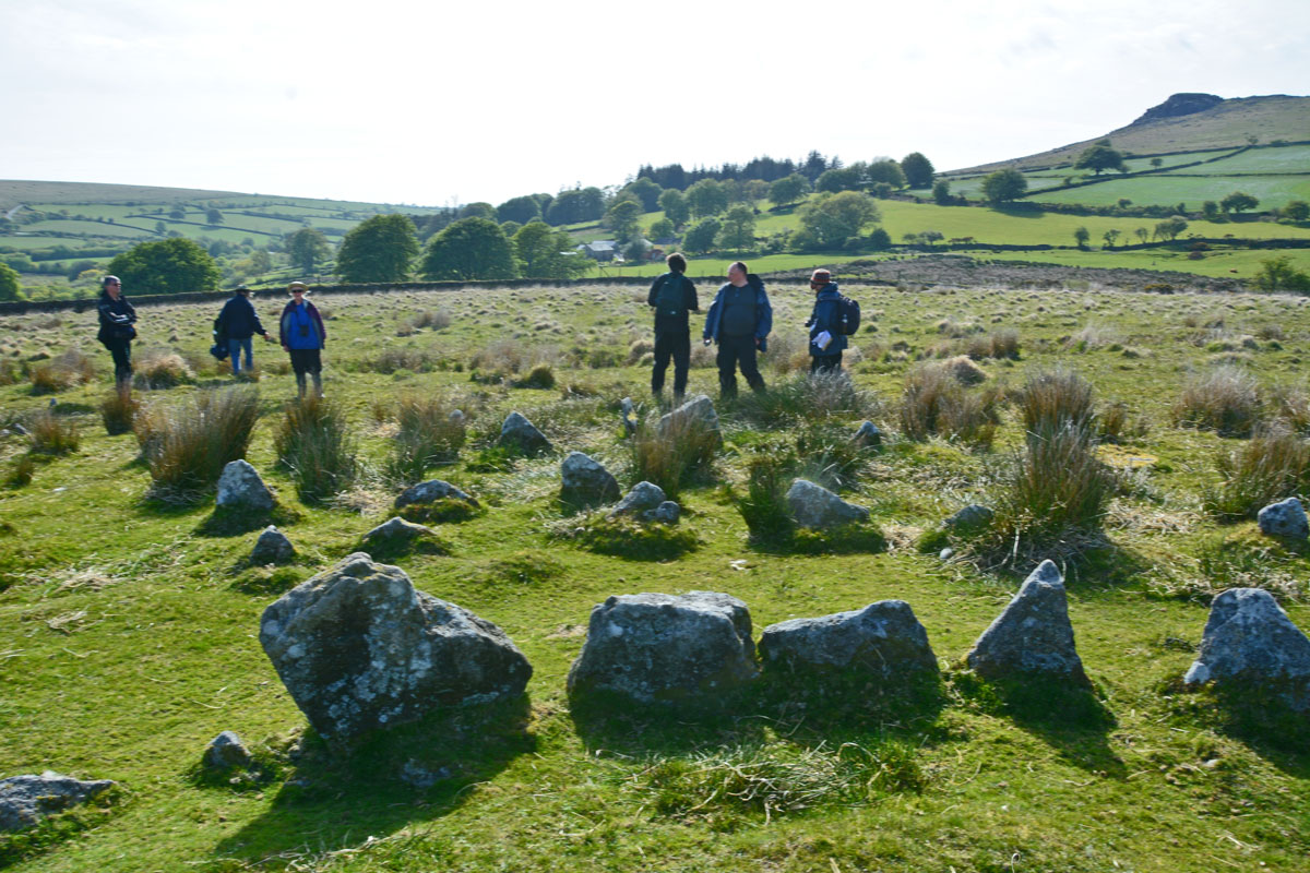 Standing towards the eastern side of the circle, looking south/south west towards the nearby farmhouse. This is Sandy G's Intrepid Dartmoor Expedition group talking about the stone row which runs from the south western side of the outer circle. 