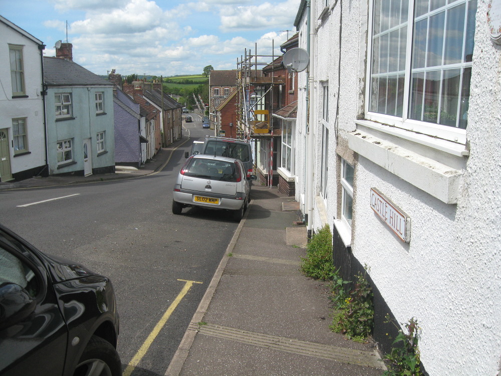 Following the comment about Axminster Castle, I thought I'd look for my 2014 photos for any evidence.  This is the only time I'd visited the town.  I walked right down Castle St to the railway crossing near the river.  There's a pub around here with a board with artistic interpretation of a 'castle'. 