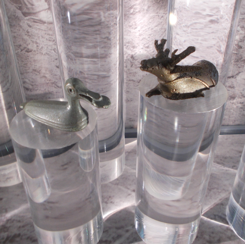 This view shows clearly the fine working of the duck figurine.  It holds a cake in its beak, and the ripples of the water are shown around its base.