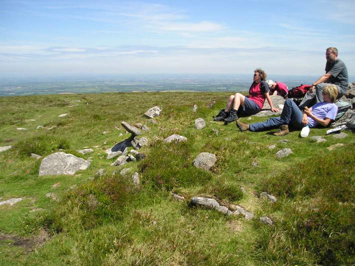 Cosdon Hill Summit Cairns, Dartmoor, Devon SX636915 to SX637917

The remains of five cairns can clearly be found at the summit of Cosdon Hill. 

The fifth cairn at the north of the hill is a very impressive beast. This cairn must be nearly complete except for a small depression within the centre. The outer edges of the cairn are nicely held in place by a ring of large stone slabs, and within t