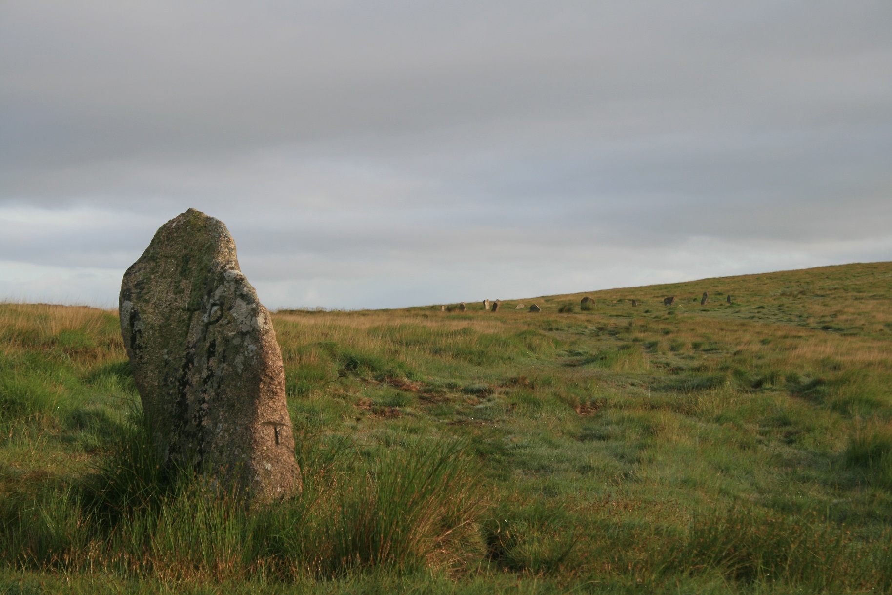 The outlier and White moor stone circle beyond.