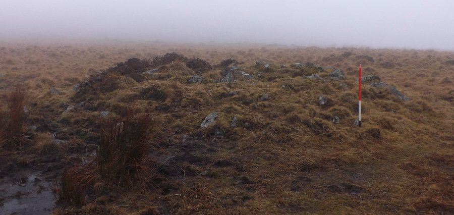 The southern cairn stands between the two stone rows on the edge of a later tinwork. View from west.
