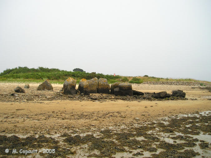 The remains of this allée couverte can be found at low tide on the beach at the southwestern corner of Ile Coalen, at the northwest entry to the Trieux river estuary. The island can be reached by walking from the mainland when the tide is out. 

It is a bit of a jumble, and has been knocked about a bit over the years. 