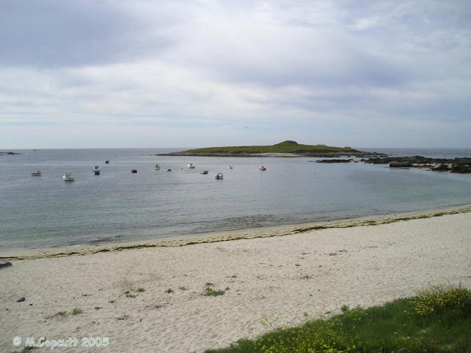 Île Carn, just off the northwestern coast of Brittany. 

Unfortunately, when I was passing here the tide was not fully out, and rising, so I could not get out onto the little island with its massive and spectacular cairn. 

I tried stopping nearby for the night, which would have let me get out onto the island next morning, but the local campsite was closed and deserted, and I had worldly need