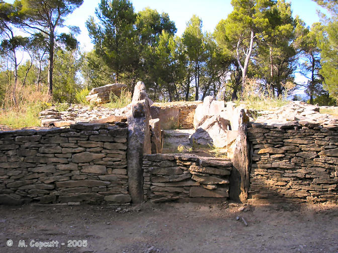 Allée Couverte de Saint-Eugène The monument consists of a circular stone wall containing a stone cairn, about a metre high and about 25 metres in diameter, with upright slabs every 5 metres or so around its circumference.
Within this is the remains of a massive structure, and a partitioned chamber 15 metres long, lined with large slabs.