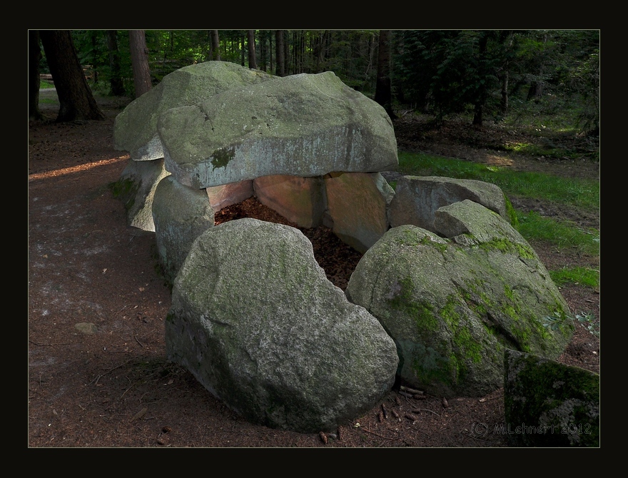 The short, but massive three capstone chamber (one is robbed), viewed from the NE. As a more rare feature the chamber is not halfways filled with earth as in most other cases. Hence it is possible to get an idea of nearly the original clear height. 

August 2012