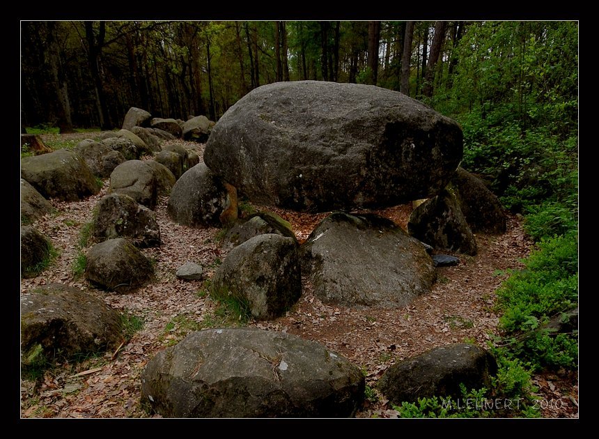 Close-up of the passage graves' eastern end showing capstone C17 (counting from the West) and parts of the double oval enclosure. Clear length of the chamber is 25,5m [1]. The capstones are supported by 53 orthostats. The original barrow is almost completely removed as well as the dry-walling. The chamber is halfway embedded into the sandy ground. May 2010

[1] Sprockhoff, Schwieger in: Körner,