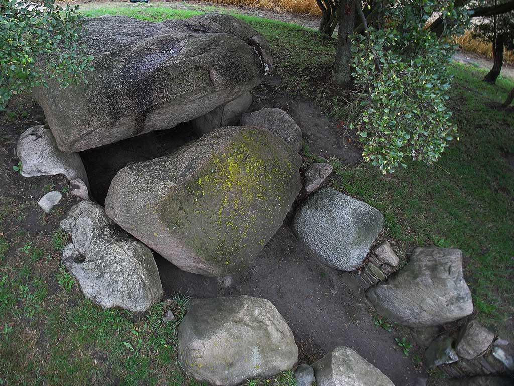 A restored 'Grossdolmen' in the area of Rerik at the Baltic Sea.
The restoration took place in 1967.
Before the chamber was enclosed in the remains of a barrow,
which is now lowered considerably.
The chamber is build of six uprights on the north, east and west side.
A passage is set at the south side.
Two capstones are on the chamber, a bigger one north and
a smaller, now tilted, on the sou