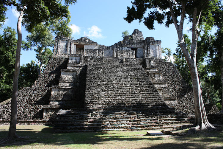 Dzibanche Edificio 6 - The Building of the Lintels.
It is a pyramidal platform upon which there is a temple with two vaulted galleries. The one at the rear has a special design with tensors that prevent the walls from collapsing at their corners; above it a solid trapezoidal cresting was built, vestiges of which remain.
The exposed temple belongs to the last stage of construction; its pediments were dec