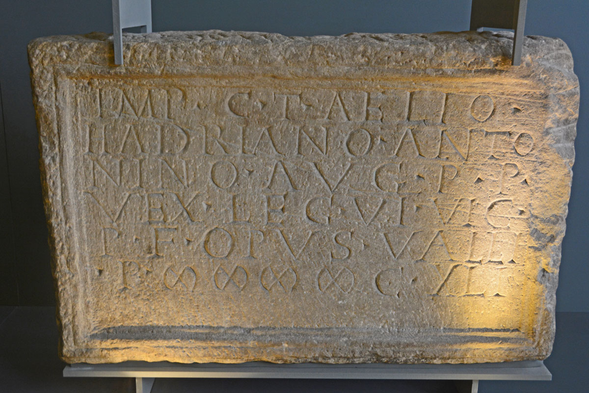 Museum accession no. GLAHM:F.13, also recorded as Canmore 43272, one of two distance slabs found near each other. The inscription (in shorthand form) reads:[I]MP C T AE [H]ADRIANO [A]NTONINO [AV]G PIO P P [VEX L]EG XX VV [PP IIII C]DXI
'For the Emperor Caesar Titus Aelius Hadrianus Antoninus Augustus Pius, Father of his  Country, a detachment of the Twentieth Valiant and Victorious Legion built 9