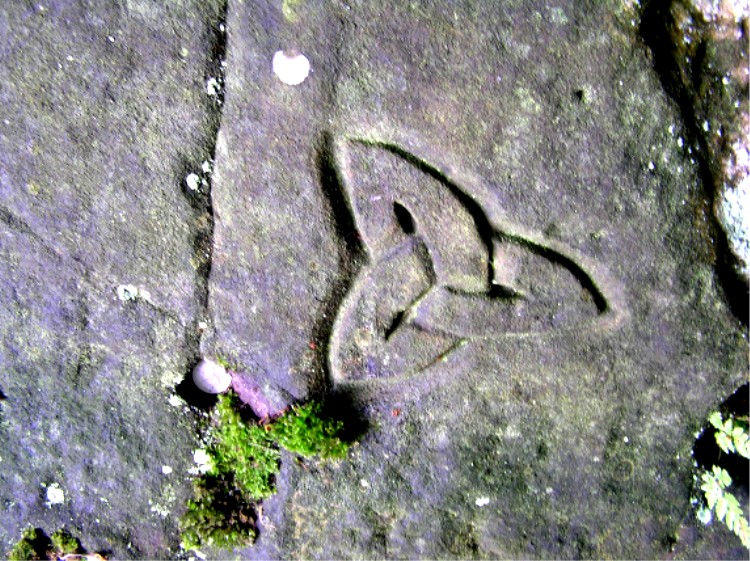 A little further around the cliff brings you to a carved Celtic trinity about 9 inches in diameter.