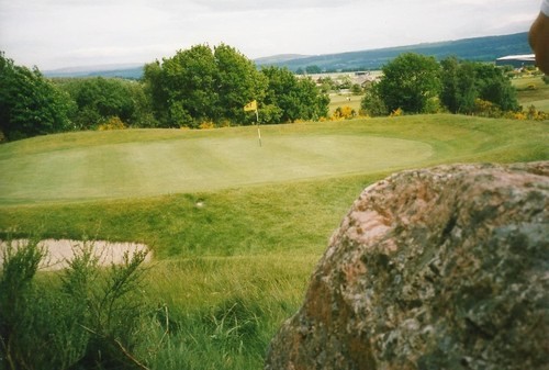 Muir of Ord henge, it's now a green on a golf course, It has a big quartz stone on site, part of this can be seen in the foreground.