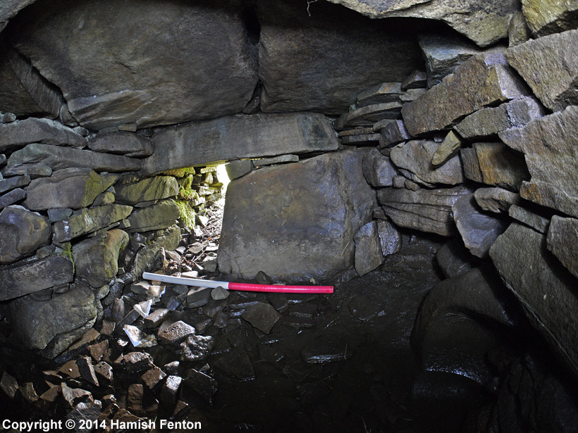 Photograph of the main chamber of Wadbister souterrain showing blocking stone and entrance from passageway.

Scale: 1 Metre

Photograph taken using a fisheye lens (very wide and somewhat distorted view).

14 September 2014