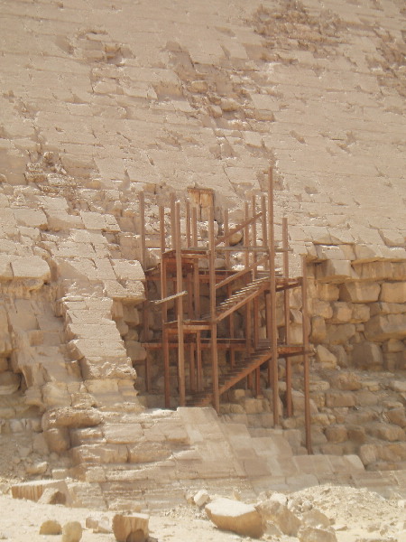 North Entrance.
Sneferu's second attempt at building a proper pyramid. Half way through construction, he changed the angle from 54 degrees to 43 degrees. It was first believed this was to avoid having the casing collapse like at Meidum, but now it is thought the weight of the material was causing cracks in the chambers. The reduced angle reduced the amount of material piling up on top. There are 