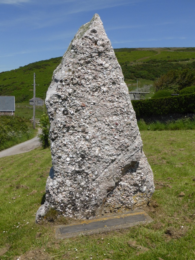 Large piece of white Rhossili Down conglomerate erected to commemorate the millenium, just outside the churchyard on a green beside the pathway up to the Down. 