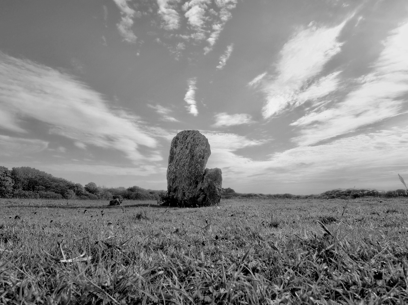 Something a little different...
The stone is 1.7m tall, 1.5m wide, and 0.4m thick, in the shape of a rounded rectangle with a distinct step, or shoulder on one side. It is thought to stand on the site of a circular timber structure that burnt down around 1395 BC. Though it now stands alone, the stone is thought to have formed part of an arrangement of smaller stones. About 940 BC a cremation buri